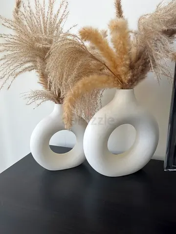 Pair of modern white ceramic loop vases with pampas grass