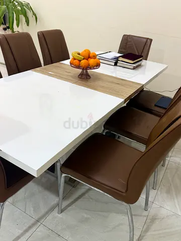 Modern white and wood dining table with 8 brown chairs