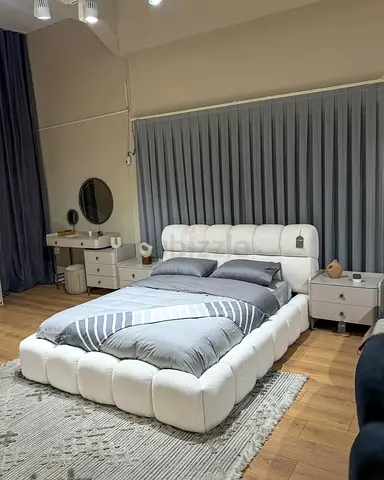 Low-profile tufted white upholstered king bed with padded frame