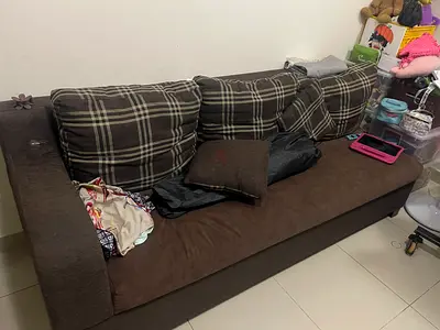 Brown three-seater fabric sofa with plaid cushions