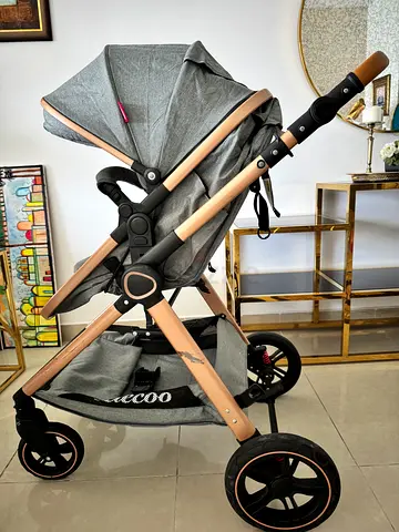 Lightly used grey pram stroller with storage basket and sun canopy