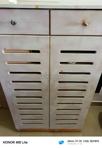 White wooden storage cabinet with slatted doors - AED 100