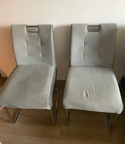 Pair of grey upholstered dining chairs with metal legs