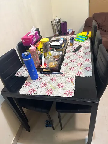 Used black dining table with 6 chairs and table mats
