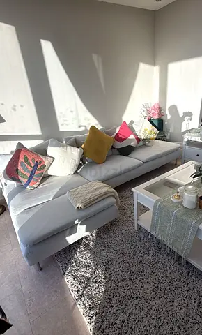 Light grey modern sectional sofa with chaise and cushionsand coffee table