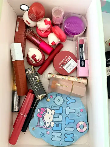 Bundle of assorted new/used lipsticks, balms and makeup essentials (Hello Kitty tin included)