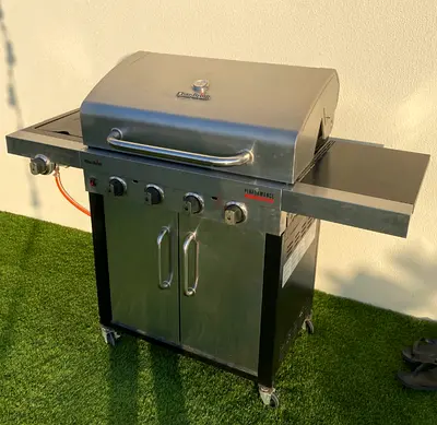 Stainless Steel 4-Burner Gas BBQ Grill with Side Shelves and Cabinet.