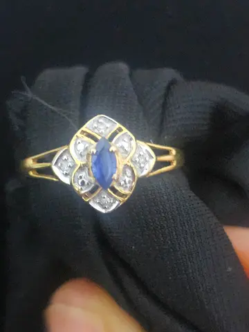 Gold ring with marquise blue sapphire and small diamonds.