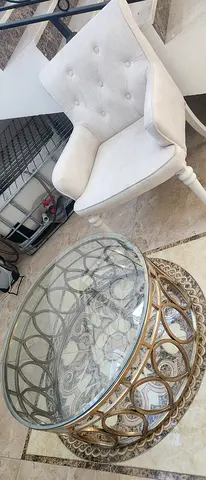 Set of 3 Light Beige Tufted Accent Chairs with a Round Glass Coffee Table.