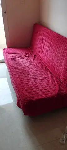 Red convertible sofa bed with quilted cover - good condition
