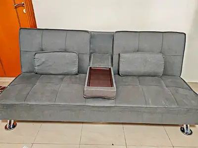 Gray convertible sofa bed with center tray and cushions