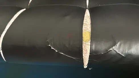 Black faux leather sofa cushion with tear — for repair or parts