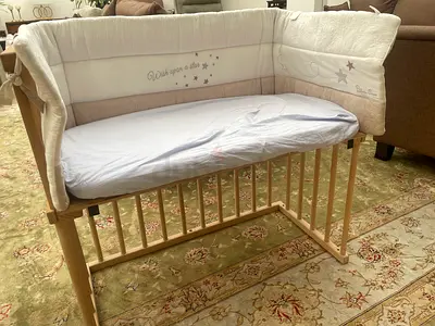 Wooden bedside crib/bassinet with padded bumpers