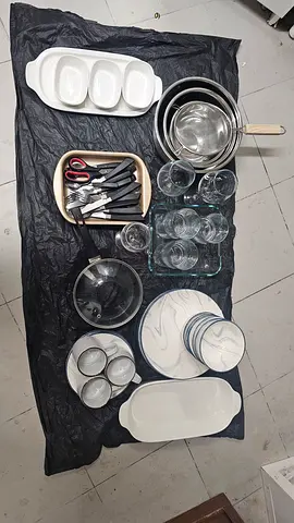 Mixed kitchenware set — plates, bowls, glasses, pans and cutlery