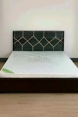 Queen size bed frame with mattress and padded headboard