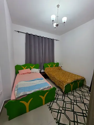 Single bed with mattress and green upholstered headboard - good condition