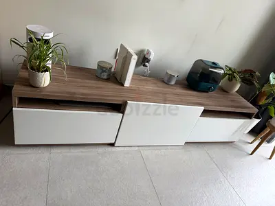 TV unit with white sliding panels — good condition. Selling because moving apartment.