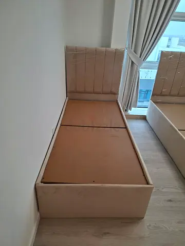 Beige upholstered bed base with headboard (single) - good condition