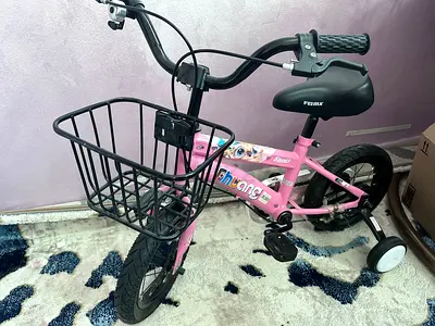 Pink kids 12-inch bicycle with training wheels and front basket