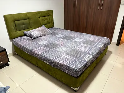 Green upholstered double bed with mattress