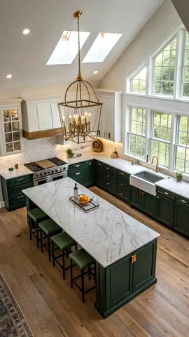 Spacious kitchen with marble island and green cabinetry