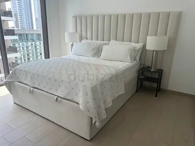 Light grey upholstered Queen bed with storage and tall channel-tufted headboard