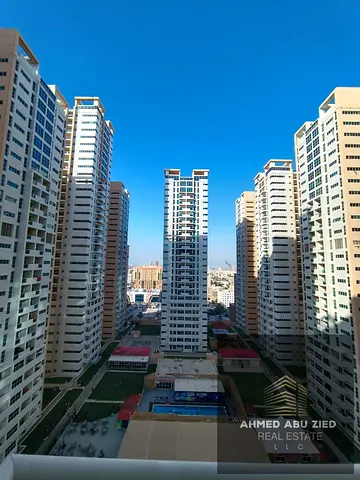 Two bedrooms and a living room for annual rent in Ajman One Towers. Features include a closed kitchen, distinctive design, spacious areas, and a prime