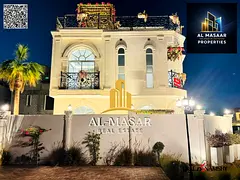 In Al Bahia area, Ajman, a corner villa with two floors and a roof, fully air-conditioned, freehold