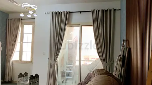 Pair of beige floor-to-ceiling curtains with blackout lining