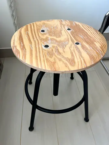 Simple round wooden bar stool with black metal legs