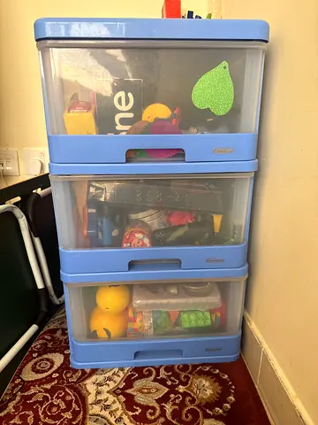 Three-tier plastic toy storage drawers with mixed toys