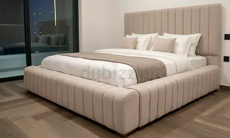 Modern upholstered king-size bed with padded headboard and frame - beige