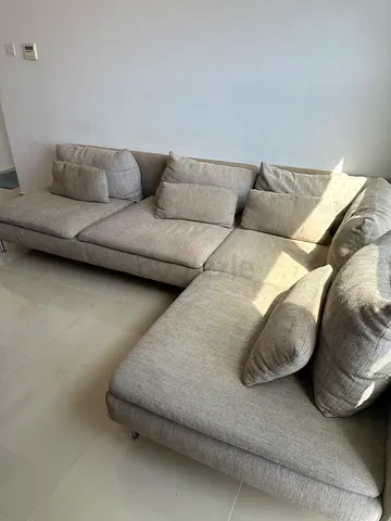 Light grey L-shaped fabric sofa with cushions