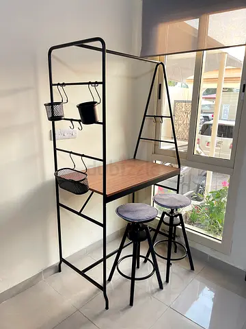 Compact kitchen island with two matching bar stools and hanging rack