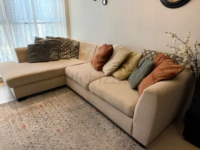 Beige L-shaped Fabric Sofa with Cushions — Good Condition