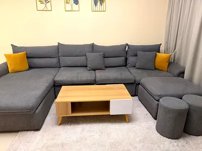 L-shaped Grey Fabric Sofa with Ottoman and Coffee Table - Good Condition