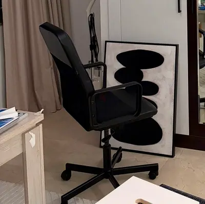 Black ergonomic swivel office chair with armrests