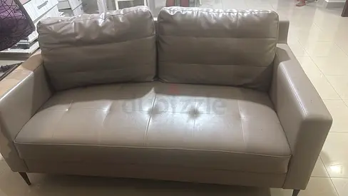 Two-seater faux leather sofa in beige — good condition