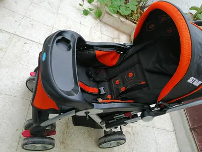 Lightly used orange and black baby stroller with tray and canopy