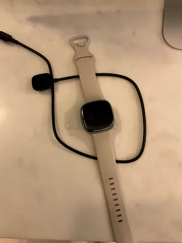 Light grey Fitbit smartwatch with charger - excellent condition