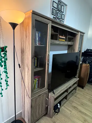 Light wood entertainment center with glass cabinets and TV stand