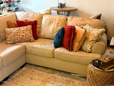 Beige L-shaped Sectional Sofa with Assorted Cushions - Good Condition