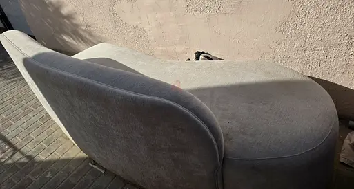 Light beige two-seater curved sofa - used