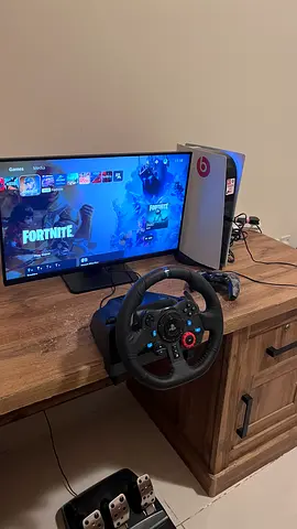 PS5 setup with racing wheel, pedals, monitor and controller - ready to play