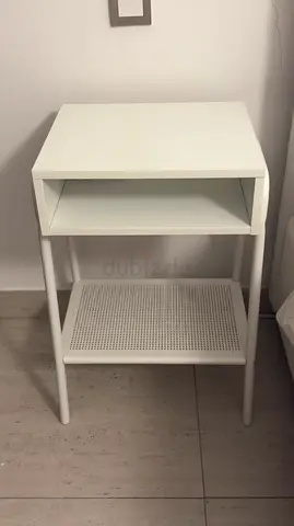 Simple white bedside table with lower shelf and open cubby