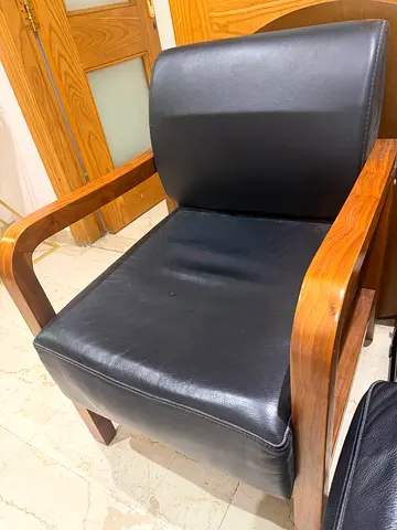 Used black leather lounge chair with wooden frame