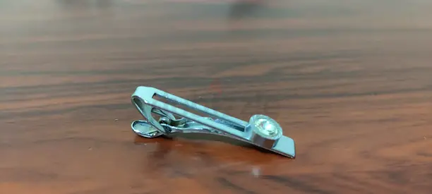 Silver metal tie clip with small decorative stone — good condition