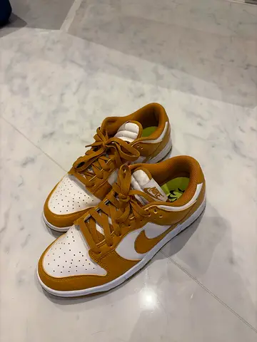 Nike Dunk Low-style sneakers, white with mustard/gold accents, used