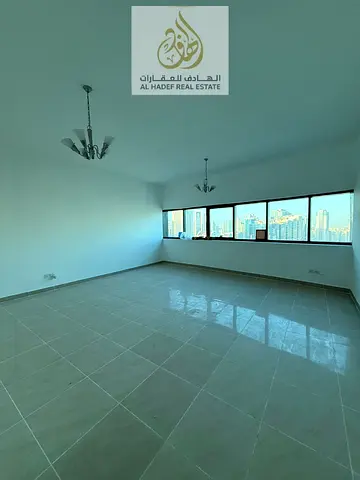 للإيجار السنوي في إمارة الشارقة بمنطقة الممزر التعاون شقة سكنية فاخرة مكونة من غرفتين وصالة مع غرفة خادمة وخزائن مدمجة بالحائط داخل برج راقٍ بموقع است