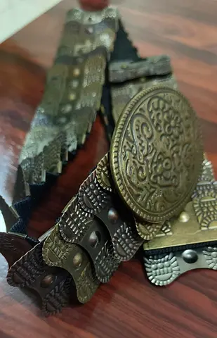 Vintage-style ornate metal waist belt with embossed medallion